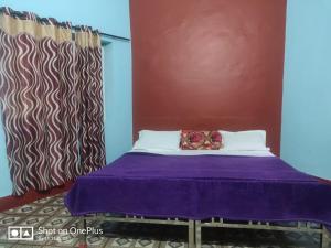 ein Bett in einem Zimmer mit einer lila Decke in der Unterkunft rigel home stays in Jāmb