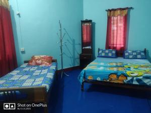 zwei Betten in einem Zimmer mit blauen Wänden in der Unterkunft rigel home stays in Jāmb