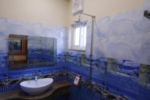 y baño de azulejos azules con lavabo y ducha. en Gold Max Hotel, en Lahore