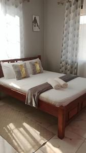 een slaapkamer met een groot bed met een hoofdeinde bij Flynn Stays in Bamburi