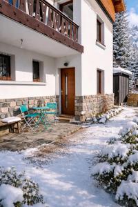 een huis met een houten deur in de sneeuw bij Appart avec Jardin & Vue Montagne - Proche Ski Briançon Serre Che in Villar-Saint-Pancrace