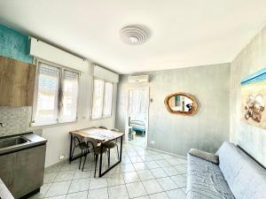 a kitchen with a table and chairs in a room at AppArt 24 city center parking and Sea Design district in Lignano Sabbiadoro