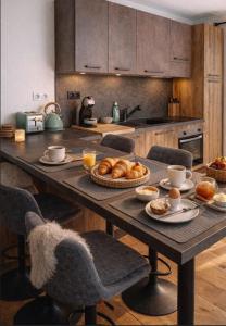 een keuken met een tafel met croissants bij Appart avec Jardin & Vue Montagne - Proche Ski Briançon Serre Che in Villar-Saint-Pancrace