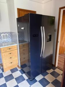 a stainless steel refrigerator in a kitchen with a checkered floor at Andover Bungalow in Penton Mewsey