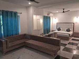 ein Wohnzimmer mit Sofa und Bett in der Unterkunft Ashoka Resort in Begusarai