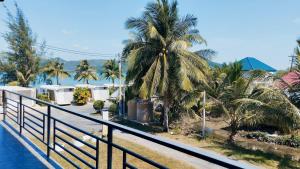 Blick auf ein Resort mit Palmen und einem Zaun in der Unterkunft Leamsai Whisper Home in Thalang