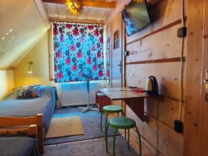 a bedroom with a bed and a desk and a window at Willa pod Jodłą in Poronin