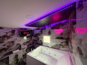 een badkamer met een bad en een klok aan de muur bij Maison avec jacuzzi in Villeurbanne