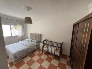 a bedroom with a bed and a crib in it at My home in Tétouan