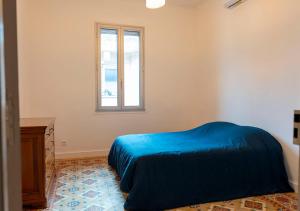 una camera da letto con un letto blu e una finestra di Chez Jojo a Port-Vendres