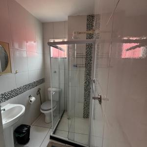 ein Badezimmer mit Dusche, Toilette und Waschbecken in der Unterkunft Casa do Rocco in Cabo Frio