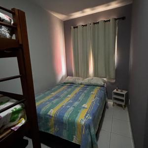 ein kleines Schlafzimmer mit einem Bett und einem Fenster in der Unterkunft Casa do Rocco in Cabo Frio + 1 Foto