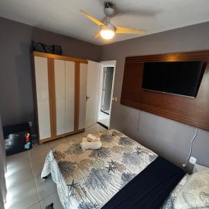 ein Schlafzimmer mit Bett und Flachbildfernseher in der Unterkunft Casa do Rocco in Cabo Frio