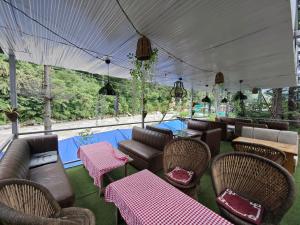een restaurant met stoelen en tafels en een zwembad bij Teji's Riverside Cottages in Kasol