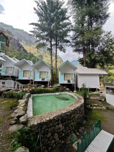 een golfbaan in een resort met een keermuur bij Teji's Riverside Cottages in Kasol