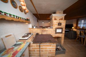 a kitchen with a brick stove and a stove top oven at Chalupa SKI Jezersko in Vígľaš