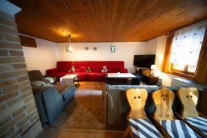 a living room with a couch and a red couch at Chalupa SKI Jezersko in Vígľaš