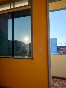 een uitzicht op de zonsondergang vanuit het raam van een gebouw bij Casa das hortas in São Luís