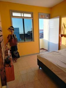 een slaapkamer met een bed en een groot raam bij Casa das hortas in São Luís
