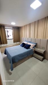 a bedroom with a bed with blue sheets and a window at Luxo e Requinte em um só lugar! in Maceió +52 photos