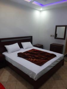 een slaapkamer met een bed met een deken erop bij Skylark in Dargai