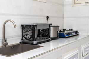 a kitchen counter with a toaster and a sink at KKJ House in Zanzibar City