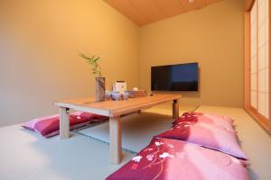 a living room with a table and a tv at 朱鷺ノ清101 in Odawara +20 photos
