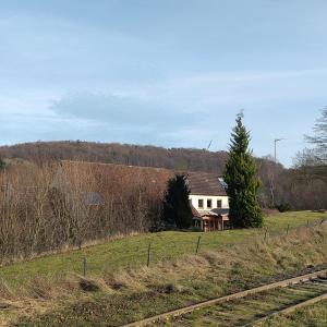 ein Haus mitten auf einem Feld mit Bahngleisen in der Unterkunft Ferienwohnung - Alte Mühle Extertal in Extertal + 15 Fotos