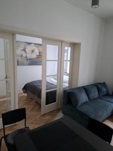 un soggiorno con un divano blu e uno specchio di CanvasHome Apartamenty a Katowice