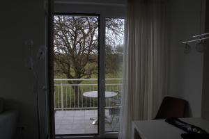 een kamer met een open deur naar een balkon met een tafel bij Destination Markgräfler Land in Bad Bellingen +3 foto's