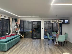 ein Wohnzimmer mit einem Weihnachtsbaum, einem Bett und einem Tisch in der Unterkunft Cuibul lui Răzvan - Domeniul Barabuc Colibița in Colibiţa
