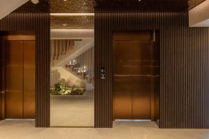 two brown elevators in a building with a staircase at Ianmamaia in Mamaia