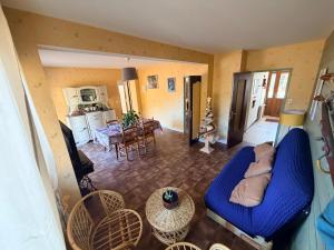 een woonkamer met een blauwe bank en een tafel bij Gîte de famille dans les Vosges in Saint-Maurice-sur-Moselle