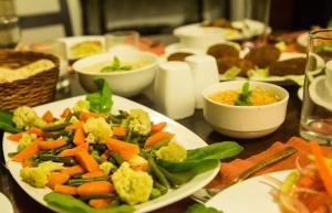 a table with a plate of vegetables on a table at Fredy's Bungalow near Nainital in Bhīm Tāl