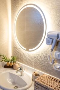 a bathroom with a sink and a round mirror at Umbi Chalet in Dahab