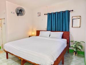 TR Bungalow في Ban Tha Rua: غرفة نوم بسرير ابيض كبير وستارة زرقاء