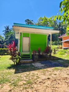 TR Bungalow في Ban Tha Rua: منزل أخضر مع باب في ساحة