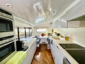 een keuken met witte kasten en een kookplaat oven bij Mimou Accommodation breakfast on yacht in Yasmine