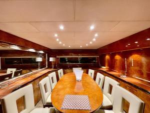 een eetkamer met een houten tafel en witte stoelen bij Mimou Accommodation breakfast on yacht in Yasmine