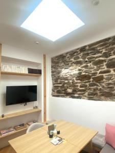 a living room with a table and a stone wall at kremsoase in Krems an der Donau