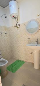 een badkamer met een toilet, een wastafel en een spiegel bij Temesegen Hotel in Āksum