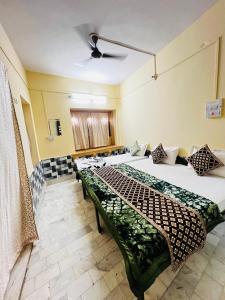 een kamer met 2 bedden en een bank bij Hostel Desert Routes in Jaisalmer