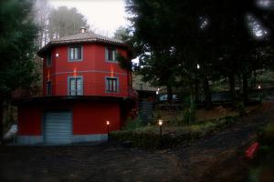 una casa rossa con un balcone sopra di Etna Nord House a Linguaglossa