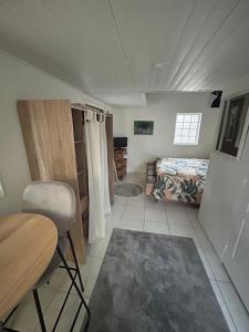 a bedroom with a bed and a table and a chair at Appartement meublé indépendant Parking privé Proche gare & Paris in Mériel