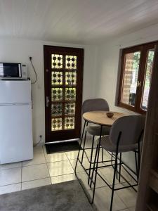 a kitchen with a table and chairs and a refrigerator at Appartement meublé indépendant Parking privé Proche gare & Paris in Mériel