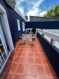 een terras met een tafel en stoelen op een balkon bij Vista Malbec 1 in Ciudad Lujan de Cuyo