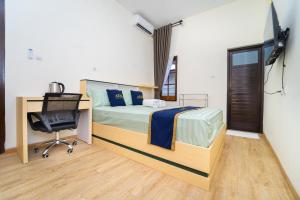 a bedroom with a bed and a desk and a computer at Semenrante Living By ARBA in Solo