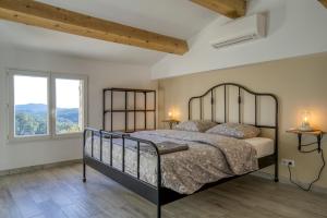 a bedroom with a bed and a large window at Cottage les Marjoris Tanneron in Tanneron