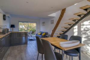 a kitchen and dining room with a wooden table and chairs at Cottage les Marjoris Tanneron in Tanneron +17 photos