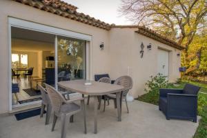 a patio with a table and chairs on a patio at Cottage les Marjoris Tanneron in Tanneron
